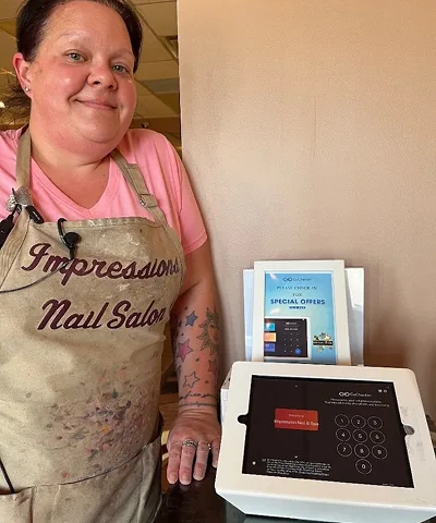 Salon customer using Go Check In tablet at nail salon front desk