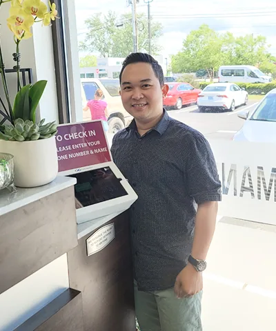 Salon customer using Go Check In tablet at nail salon front desk