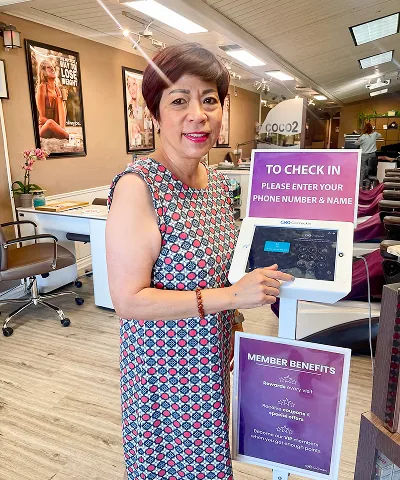 Salon customer using Go Check In tablet at nail salon front desk