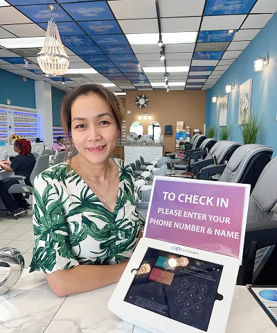 Salon customer using Go Check In tablet at nail salon front desk