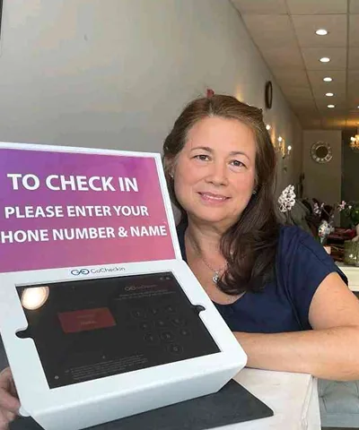 Salon customer using Go Check In tablet at nail salon front desk
