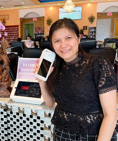 Salon customer using Go Check In tablet at nail salon front desk