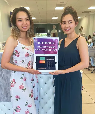 Salon customer using Go Check In tablet at nail salon front desk