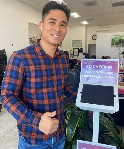 Salon customer using Go Check In tablet at nail salon front desk
