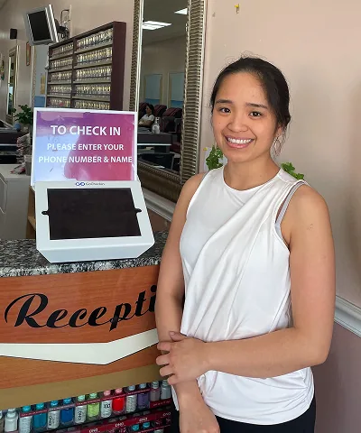 Salon customer using Go Check In tablet at nail salon front desk
