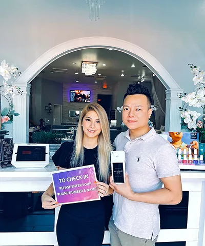 Salon customer using Go Check In tablet at nail salon front desk