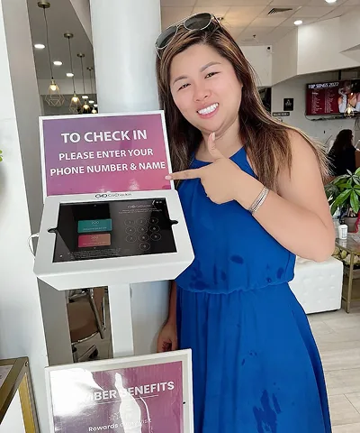 Salon customer using Go Check In tablet at nail salon front desk
