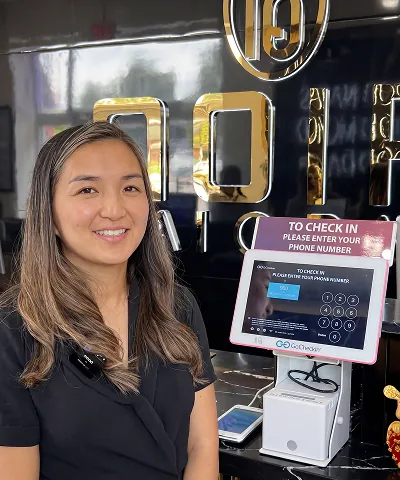 Salon customer using Go Check In tablet at nail salon front desk