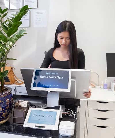 Salon customer using Go Check In tablet at nail salon front desk