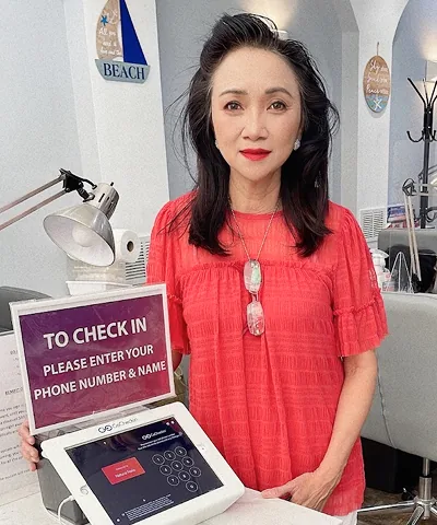 Salon customer using Go Check In tablet at nail salon front desk