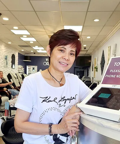 Salon customer using Go Check In tablet at nail salon front desk