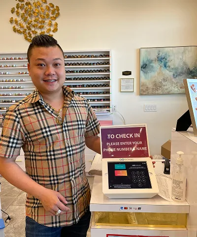 Salon customer using Go Check In tablet at nail salon front desk