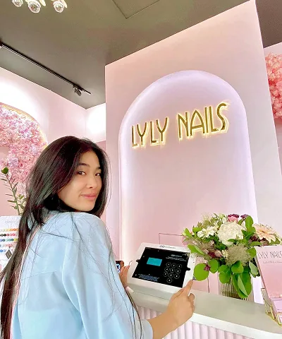 Salon customer using Go Check In tablet at nail salon front desk