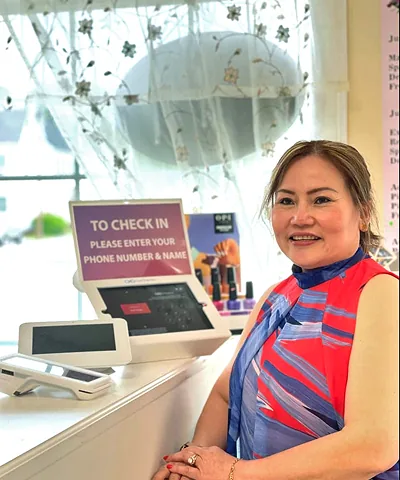 Salon customer using Go Check In tablet at nail salon front desk